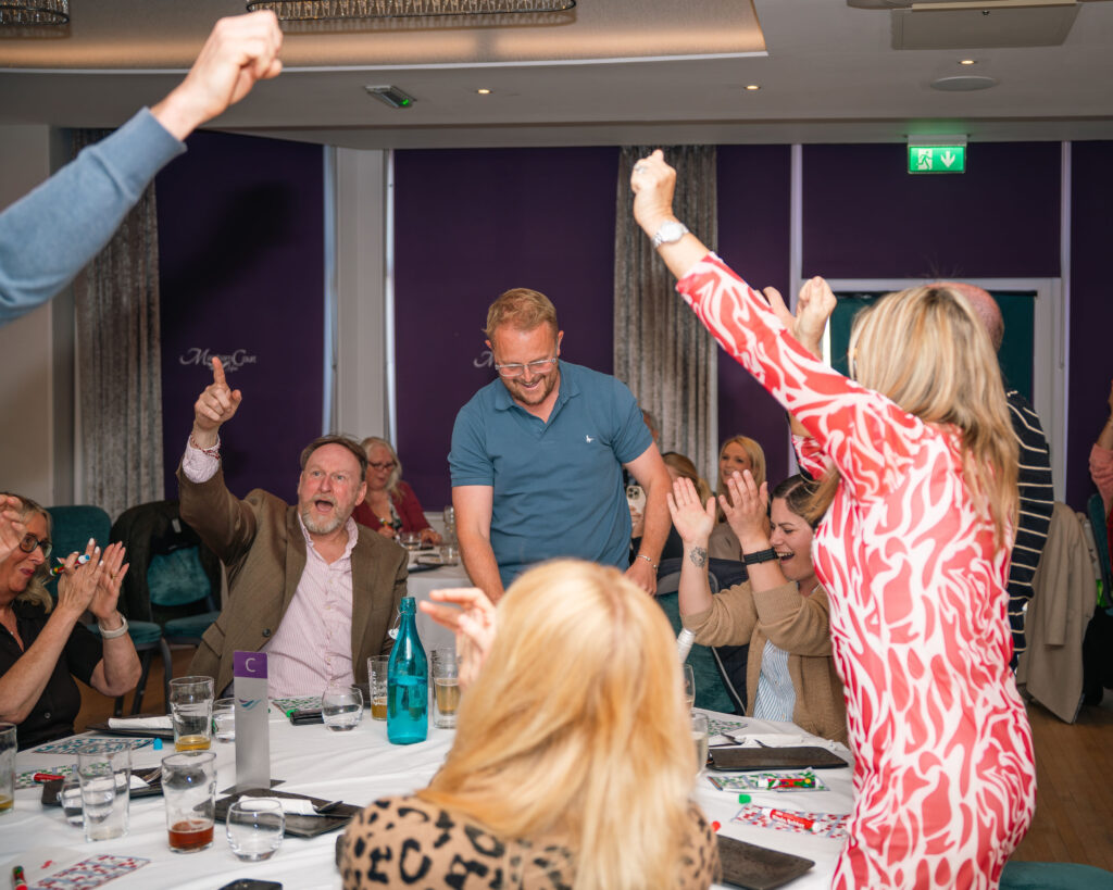 Guests clapping to celebrate at a games night at the Marsham Court Hotel